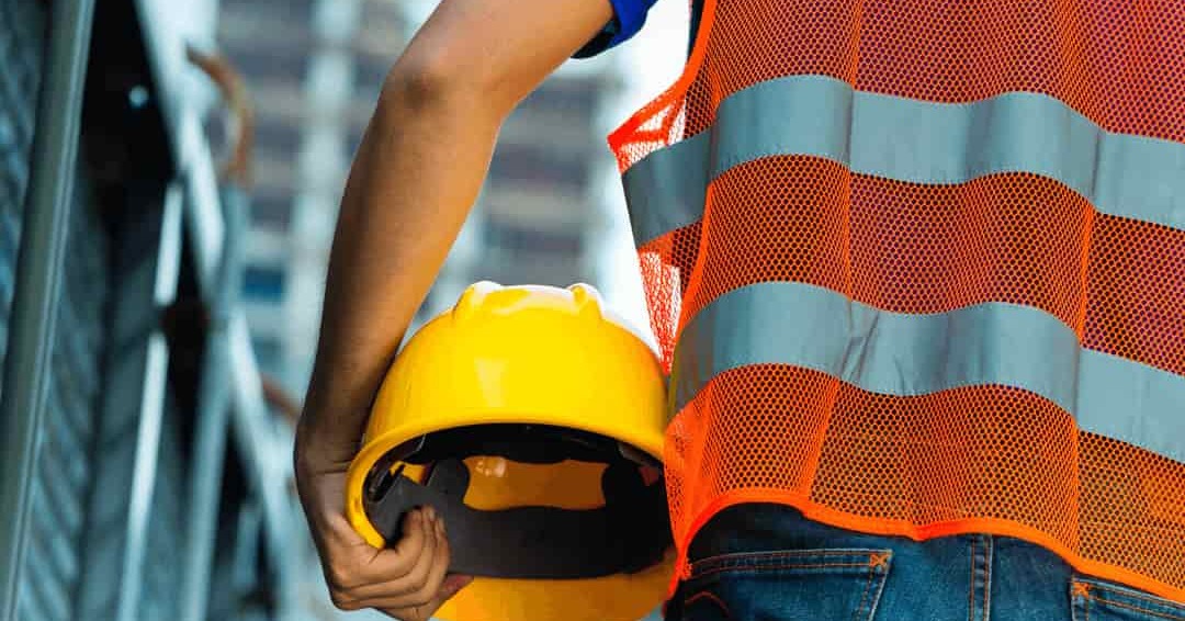 worker holding hat on the job site - optimized